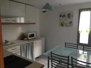 a kitchen with a table and a microwave at L Ecrin, duplex classé 2 étoiles, au cœur de Villandry in Villandry