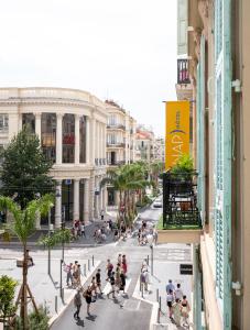 a group of people crossing a street in a city at Hotel Nap By HappyCulture in Nice