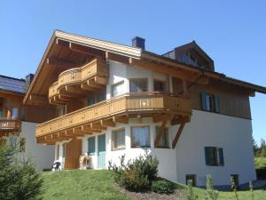 Una casa grande con balcones de madera en la parte superior. en Filzsteinalpe Hochkrimml en Krimml