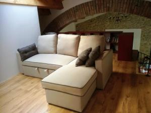 a living room with a white couch with pillows at Agriturismo Coradosso "Il Fienile" in Selvapiana +2 photos