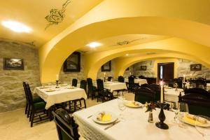 a restaurant with tables and chairs in a room at Conacul Benke in Moacşa
