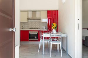 a kitchen with red cabinets and a table and chairs at Villetta Silvana by Wonderful Italy in Ostuni