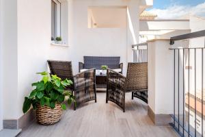 a balcony with chairs and a table on a building at Casco Antiguo 1 Piscina, Terraza y Parking by Vero in Altea