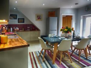 a kitchen and dining room with a table and chairs at Rathbone Cottage in Stow on the Wold