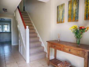 a staircase in a home with a vase of flowers on the wall at Greystones Cottage in Bourton on the Water