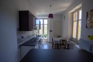a kitchen with a black counter top and a table at Appartamento con vista a Torre Pellice in Torre Pellice