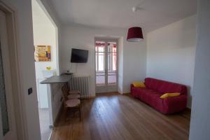 a living room with a red couch and a television at Appartamento con vista a Torre Pellice in Torre Pellice