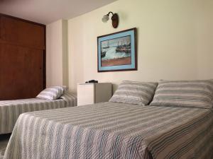 1 dormitorio con 1 cama y una foto en la pared en Hotel Mar Azul Inn, en Santa Marta