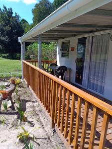 a front porch with a wooden railing and a patio at Nadine's Self - Catering Accommodation in Stormsrivier