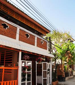 a brick building with an orange and white facade at Villa Vacay Chiang Mai in Chiang Mai +8 photos