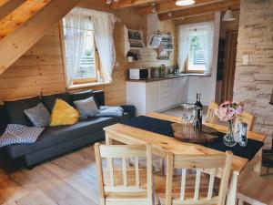 a living room with a couch and a table at Domek w Borowikowym Zaciszu in Falsztyn