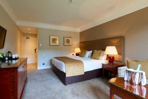 a hotel room with a large bed and a couch at Coldra Court Hotel by Celtic Manor in Newport
