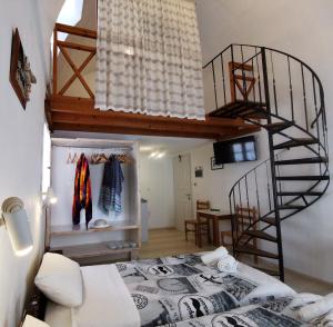 a room with a bed and a spiral staircase at Aretousa Villas in Perissa