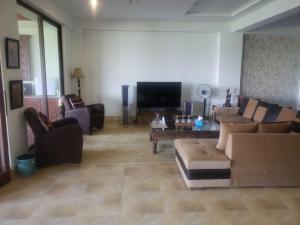 a living room with couches and a flat screen tv at Mountain View House in Murree