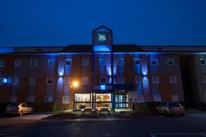 a building with a lit up sign in front of it at ibis budget Marne la Vallée Chelles in Chelles