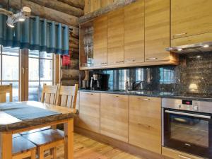 une cuisine avec des placards en bois et une table en bois avec une salle à manger dans l'établissement Holiday Home Luostakka small by Interhome, à Ylläsjärvi