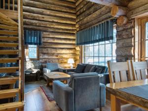 a living room with wooden walls and couches and tables at Holiday Home Luostakka small by Interhome in Ylläsjärvi