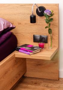 a bedside table with books and a vase of flowers at VIP Apartamenty number 6 in Lublin