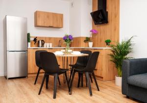 a kitchen with a table and chairs and a refrigerator at VIP Apartamenty number 6 in Lublin