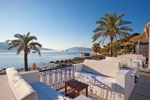 un balcon avec vue sur la plage et les palmiers dans l'établissement Salmakis Resort & Spa, à Bodrum City