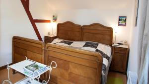 - une chambre avec un grand lit en bois et une table dans l'établissement Kutscherhaus am Weiher, à Hundsdorf