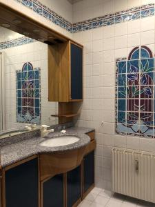 uma casa de banho com um lavatório e vitrais. em Haus Silent Apartment TOBI TOP 27 em Schladming