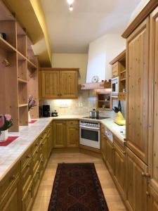 a large kitchen with wooden cabinets and a rug at Haus Silent Apartment TOBI TOP 27 in Schladming