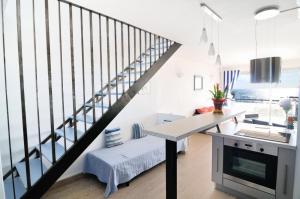 Una escalera en una habitación blanca con una mesa en Appartement Estaque, en Valras-Plage