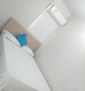 モンテリアにあるAltamira Hotelの青い枕付きのベッドが備わる小さな客室です。