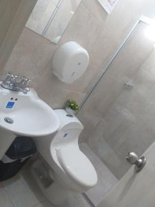 a bathroom with a toilet and a sink and a shower at Altamira Hotel in Montería