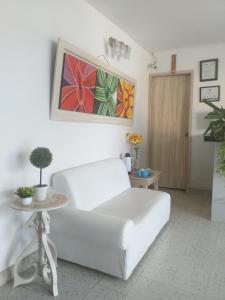 a white couch in a living room with a table at Altamira Hotel in Montería