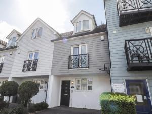 a white house with a black door and windows at 4 Fishermans Wharf in Whitstable