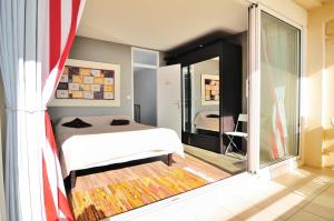 ein Schlafzimmer mit einem Bett und einem großen Fenster in der Unterkunft Appartement Estaque in Valras-Plage