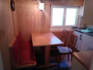 eine Küche mit einem Tisch und Stühlen sowie einem Fenster in der Unterkunft Apartment Sattelboden 4 by Interhome in Engelberg