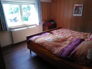 Bett in einem Zimmer mit einem Fenster und einem Bett sidx sidx sidx sidx in der Unterkunft Apartment Sattelboden 4 by Interhome in Engelberg