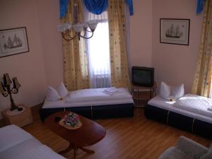 فندق غارني دجاران في أوفنباخ: غرفة معيشة بها سريرين وتلفزيون