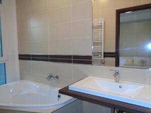 ein Bad mit einem Waschbecken und einem Spiegel in der Unterkunft Hotel Írisz in Nyíregyháza