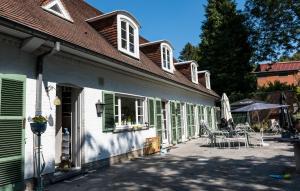 - un bâtiment blanc avec volets verts et patio dans l'établissement Gîte El Tyû, à Écaussinnes-dʼEnghien