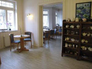 ヴィスマールにあるHotel Willertのテーブルと椅子、棚(カップ付)が備わる客室です。