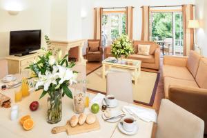 un salon avec une table avec un vase de fleurs dans l'établissement The Village – Praia D’El Rey Golf & Beach Resort, à Casal da Lagoa Seca