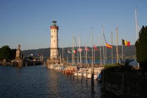 ein Leuchtturm in einem Hafen mit Booten im Wasser in der Unterkunft Ferienhof Schöngarten in Lindau