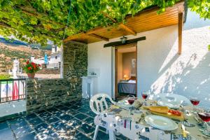 - une table avec des chaises et des verres à vin sur la terrasse dans l'établissement Alojamiento Los Pradillos, à Capileira