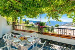 a table and chairs on a balcony with a view at Alojamiento Los Pradillos in Capileira