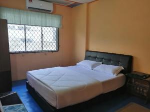 a large bed in a bedroom with a window at KLUANG BARAT HOMESTAY in Kluang
