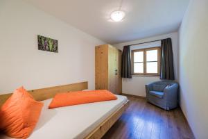 a bedroom with a bed and a blue chair at Haubenthal in Villabassa