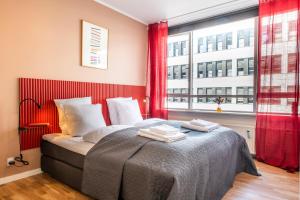 The Lakes apartments by Daniel&Jacob's في كوبنهاغن: غرفة نوم بسرير مع ستائر حمراء