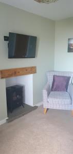 a living room with a couch and a flat screen tv at 3 Braehead in Thurso