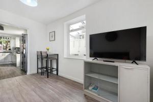 a living room with a flat screen tv on a white wall at Heathrow Living Stanwell Serviced House 5 bedrooms By 360Stays in Ashford