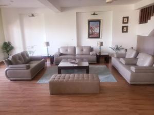 a living room with couches and a coffee table at Mountain View House in Murree