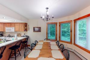 uma sala de jantar com uma mesa longa e cadeiras em Summit Solitude & Latitude Adjustment em Jay